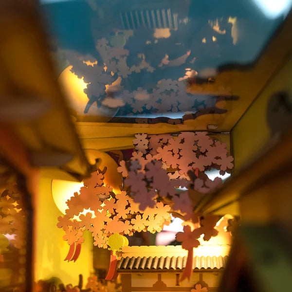Book nook with layered wooden detail and pink floral trees