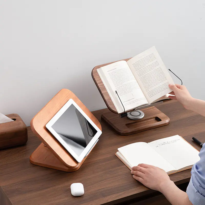 Tablet and book setup on wooden desk using rotating walnut book stand