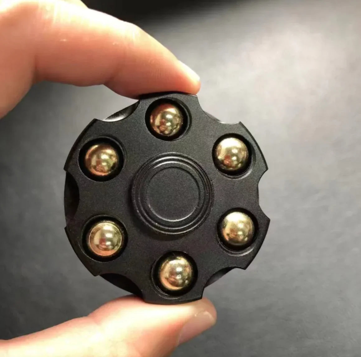 Revolver spinner toy in motion with shiny metal details