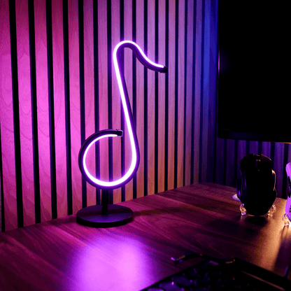 Neon light shaped like a music note on a desk with striped purple wall in the background
