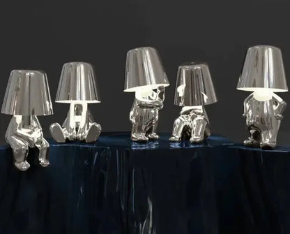 Group of silver and gold thinker lamps displayed on a black table
