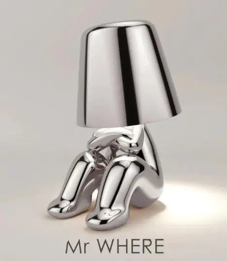 Silver thinker table lamp sitting with arms crossed